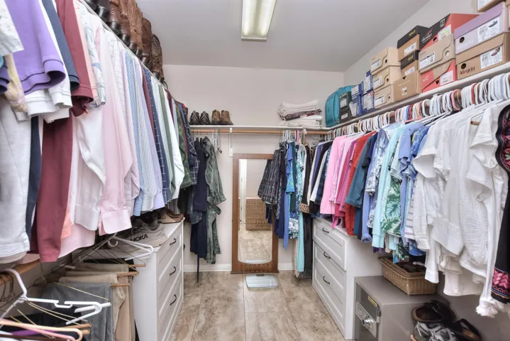 At the end of the primary bathroom is this ultra large closet.  The tile flooring was carried into this room as well...