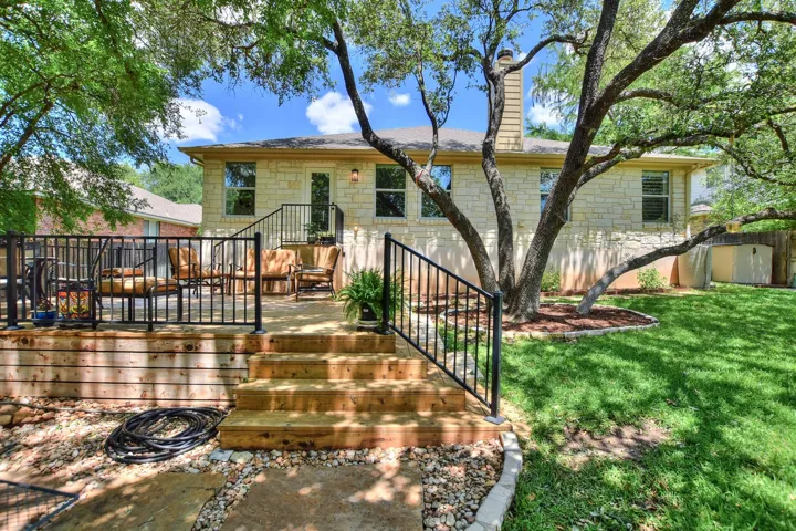 Wrought iron hand rails help you keep your balance while stepping down to eachl level of the Flagstone & cedar decking...