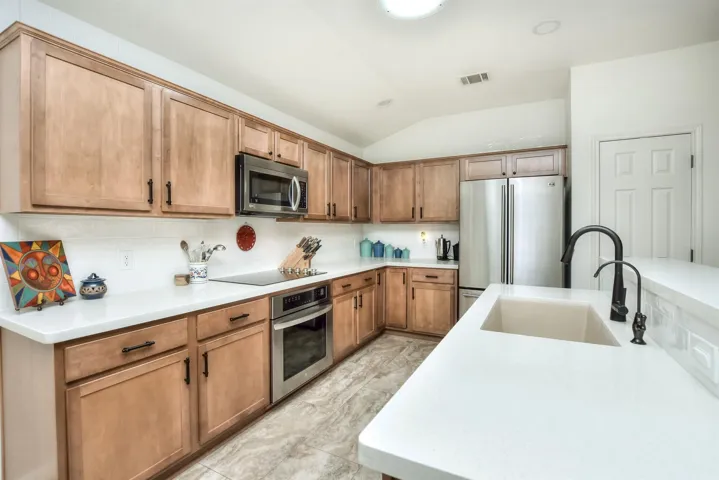 When the countertops were replaced with Quart counters, you got a large rectangular built in sink plus an updated gooseneck faucet.  Its a little hard to see in this photo, but white subway tile backsplash as added and goes all the way to the ceiling on the left here...The cabinets are the perfect color...