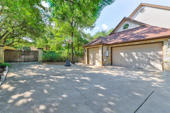Side Driveway to 3 car garage, through double gates to detached shop