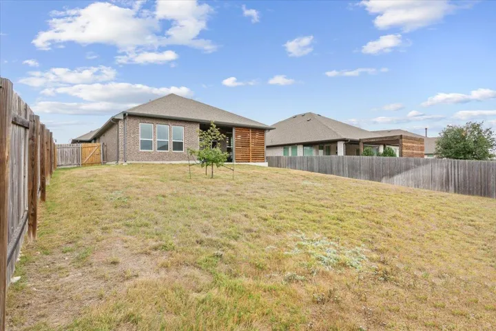 Back of property featuring a fenced backyard, a gate