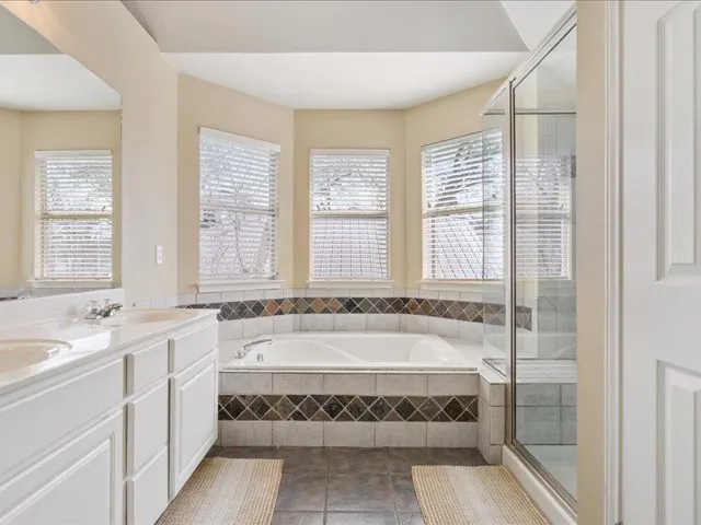 Bathroom featuring double vanity, a stall shower, a bath,