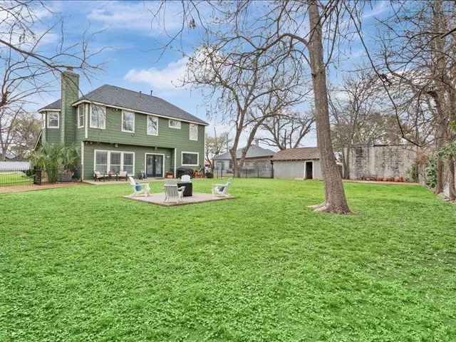 Rear view of property featuring a fenced backyard, a patio