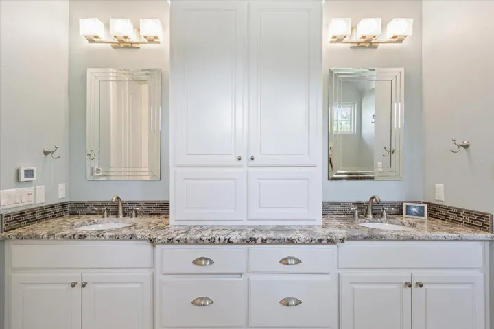Bathroom with two separate vanities & plenty of storage.