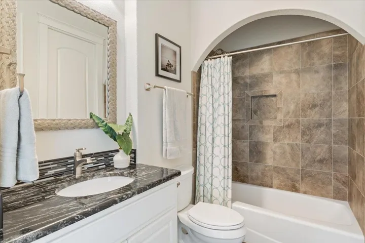 Bathroom featuring vanity, toilet, and shower / bath combination.  This bathroom is just off of Bedroom #3 and can be used for guests without entering a bedroom...