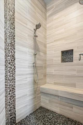 How about this walk-in shower with a bench and amazing tile walls & river stone floor?  Relax here...