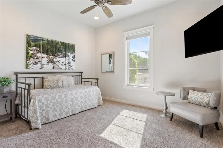 Bedroom featuring carpet, baseboards, and a ceiling fan. This bedroom is closer to the kitchen and has a full bathroom right outside the door to this bedroom....