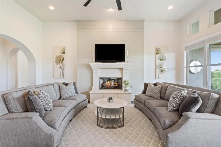 Living area featuring a ceiling fan, recessed lighting, and a large fireplace.. plus a very important wall of windows so you can enjoy your daily view...