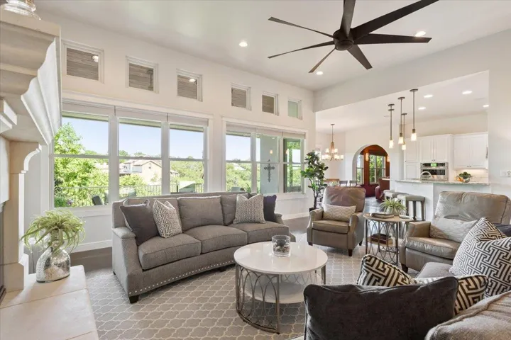 Living room featuring recessed lighting, plenty of natural light, baseboards, and a towering ceiling...
