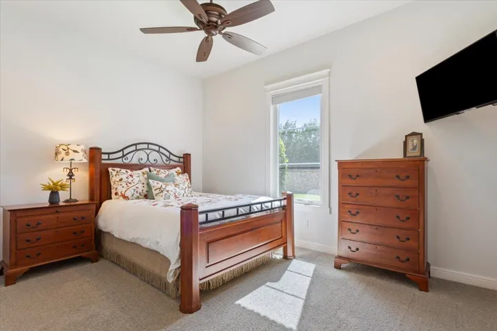 Carpeted bedroom with baseboards & a ceiling fan.  This bedroom has an en-suite bathroom private to this bedroom!