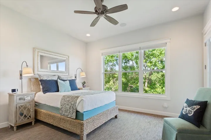 The primary bedroom easily accommodates a king-sized bed, has a ceiling fan, recessed lighting, and another invredible view to wake up to!