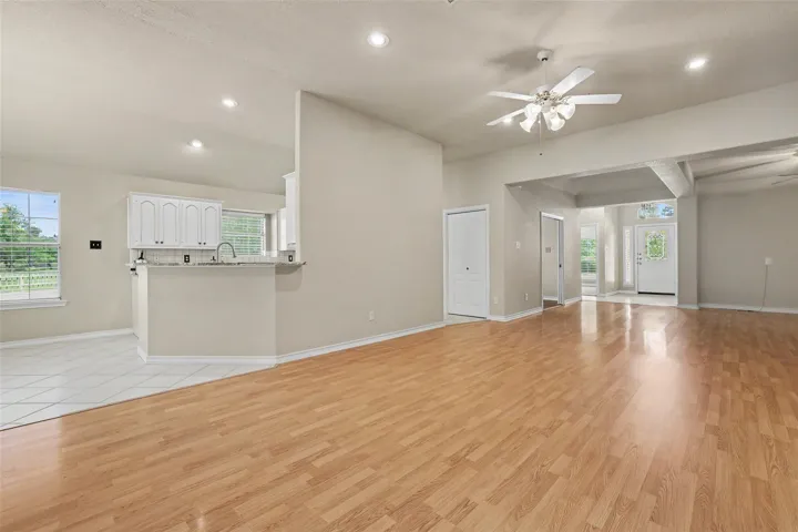 An open floorplan seamlessly connects the well-lit kitchen and spacious living areas, ideal for modern living.