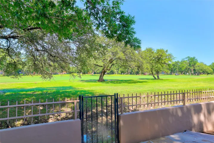 Green fairways stretch beyond the patio, offering tranquil golf course views under a clear sky.