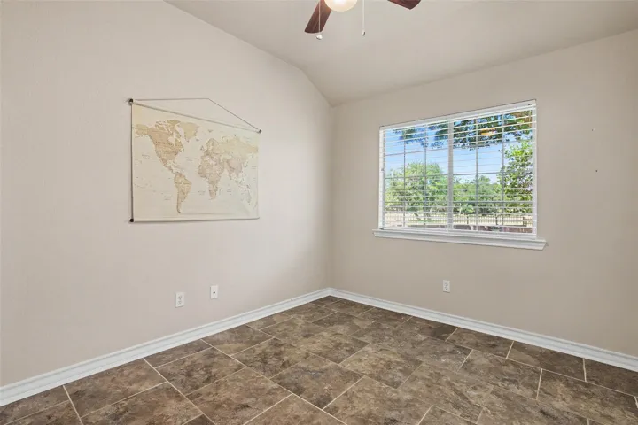 A quiet office space offers tiled flooring and a serene view of the outdoors.