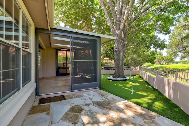 Enjoy outdoor leisure with a screened porch, flagstone patio, and a private putting green under mature trees.