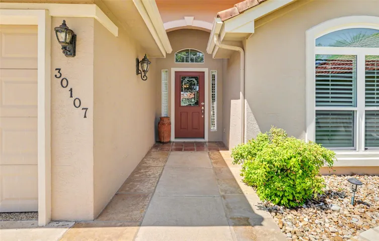 A terracotta tiled entry leads to a classic front door, welcoming you inside.