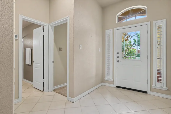 A welcoming entry features decorative glass accents and durable tile flooring.