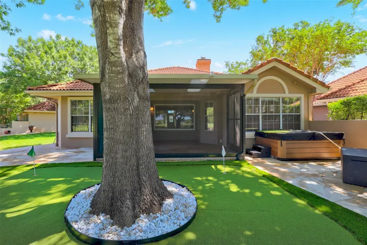 A well-maintained putting green and hot tub await on this home's inviting back patio.