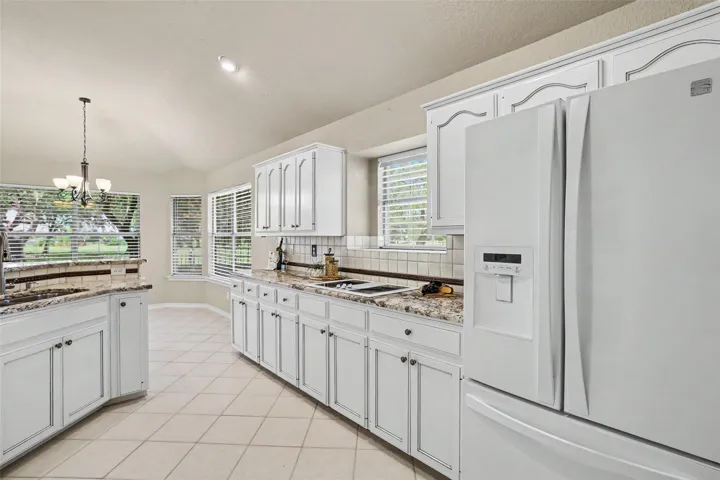 A well-appointed kitchen showcasing elegant white cabinetry and durable tiled flooring.