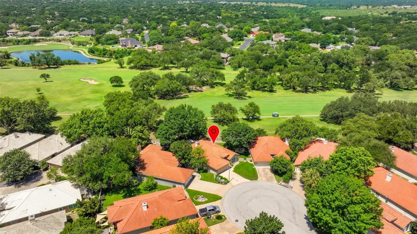 An aerial perspective showcases a vibrant community nestled alongside a verdant golf course and serene lake.