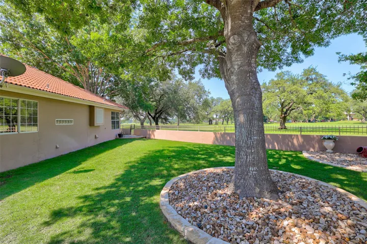 A well-maintained lawn and mature trees frame this delightful exterior, offering ample green space for enjoyment.