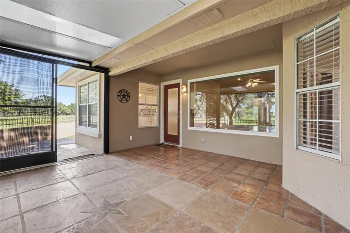A spacious covered patio invites outdoor enjoyment with durable tile flooring and views of the surrounding landscape.