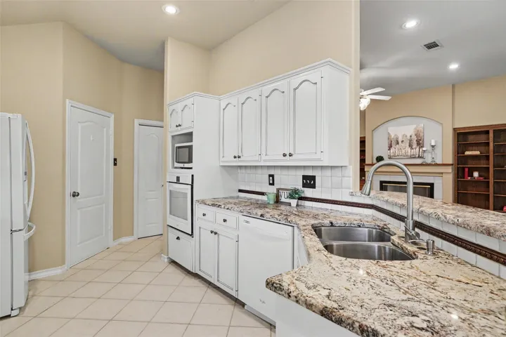 Granite counters and stainless steel appliances complete this bright kitchen.