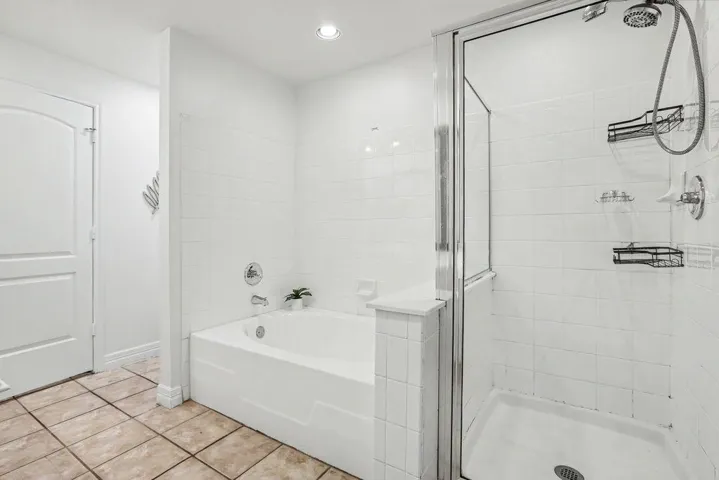 Crisp white tiling enhances a functional bath and shower combination.