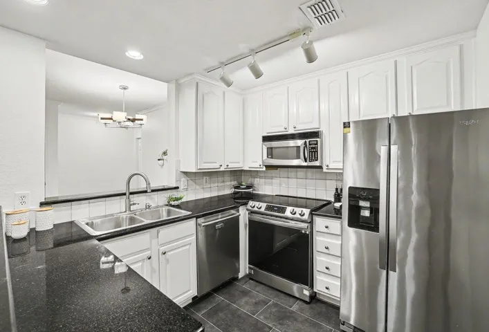 Culinary creations come to life in this kitchen, complete with dark counters and sleek appliances.