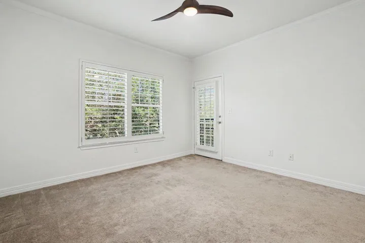 A comfortable bedroom features plush carpeting and a convenient outdoor exit.