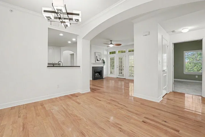 Hardwood flooring extends throughout this generous living space, connecting a modern kitchen and inviting fireplace lounge.