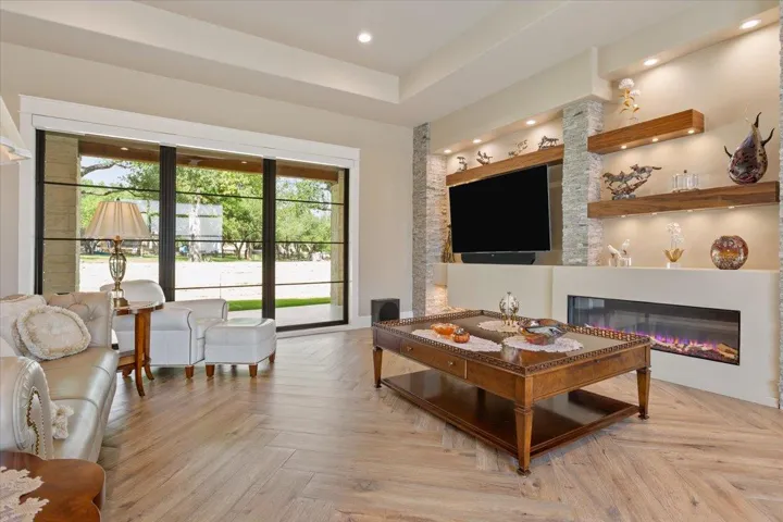 As you enter, you immediately take in the view of the heavily treed back yard.  A propane fueled fireplace to the right with natural logs. Floating shelves are rich Walnut...