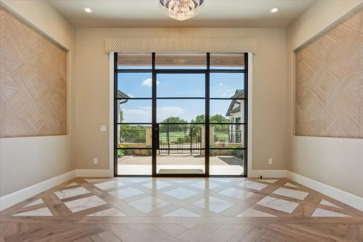Majestic Foyer makes a statement with wood and marble tile patterned flooring.  Glass doors are covered by Hunter Douglas Designer Screen Power View Shades...w/remote controls...