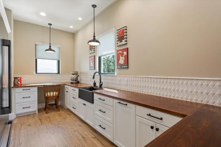 A true Butler's Pantry just off of the kitchen is so incredibly accommodating & gorgeous. Walnut Butcher Block counters, tile backsplash, another Blanco sink & a desk area highlight this side of the room...