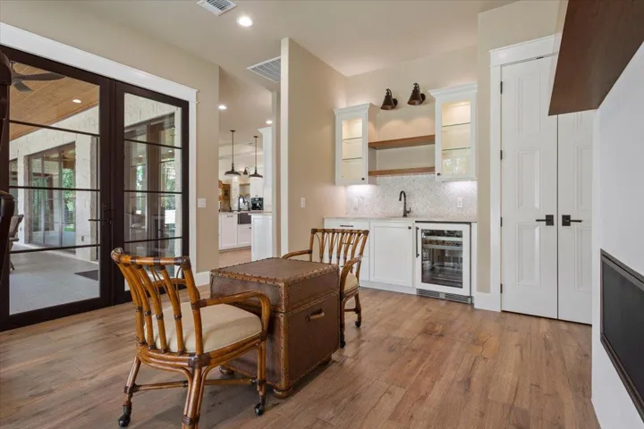 The Sellers call this a Den.  I call it the any and everything room. What a great place to play Mahjong or Poker, or Chess with your friends.  2 door closet on the right is especially built for liquor storage & has a wine fridge, Blanco sink, & floating Walnut shelves.  Built-in Fireplace on the right...