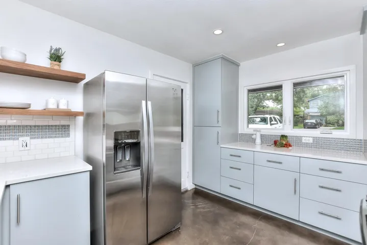Updated kitchen features quartz counter tops, tile backsplash, newer cabinets, pantry with pull outs and stainless appliances!