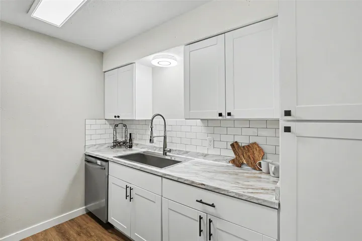 A well-appointed kitchen features white cabinetry and subway tile backsplash, offering both utility and appealing design.
