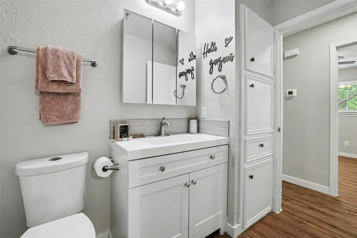 A well-appointed bathroom features a crisp white vanity and convenient built-in storage.