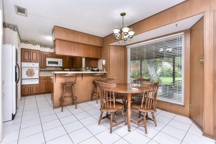 A bay window frames the light filled dining area that overlooks the inviting back yard.