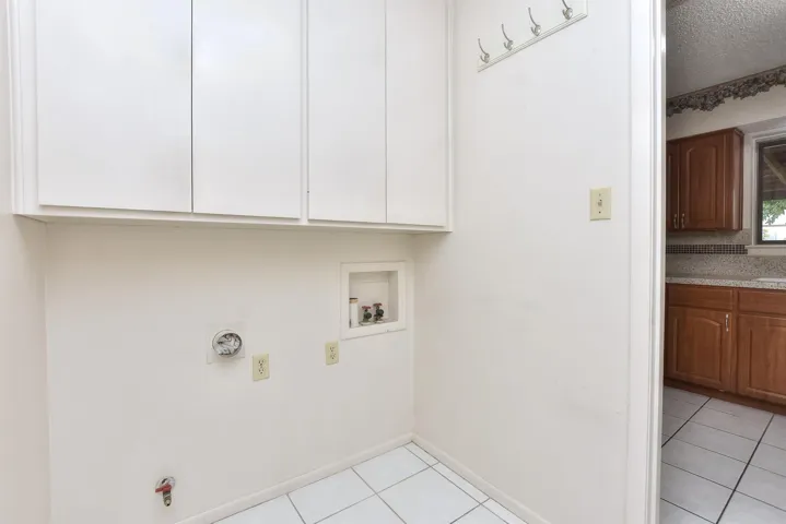 Indoor utility room sits between the kitchen and the garage.