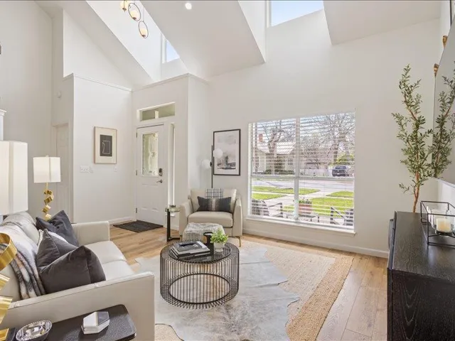 Natural light streams into this generously proportioned living room, boasting lofty vaulted ceilings.