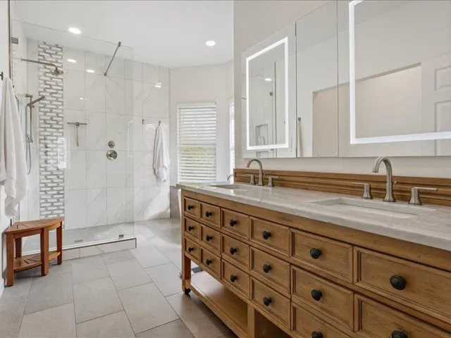 Indulge in a primary bathroom designed for rejuvenation, featuring a spacious dual vanity and a walk-in shower.