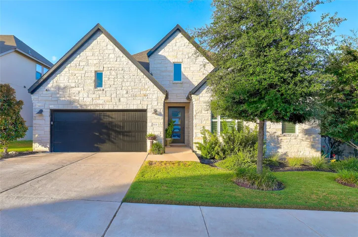 Gabled stone architecture pairs with manicured lawn.