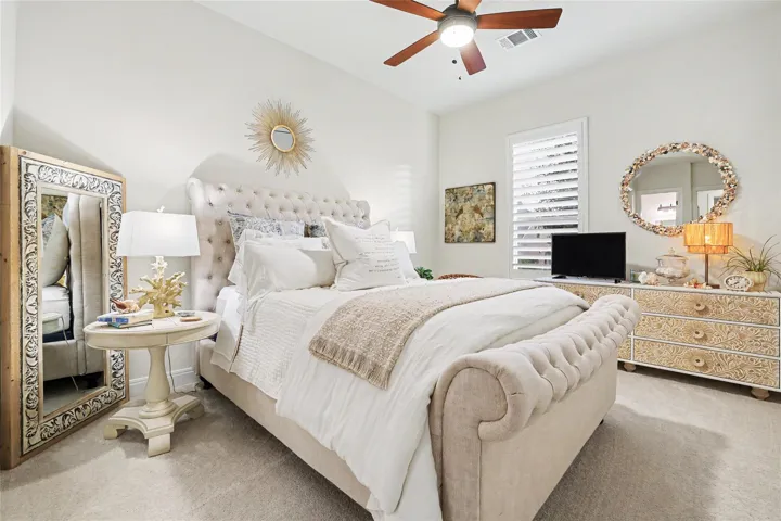 Plentiful natural light filters through wood shutters into this bedroom.