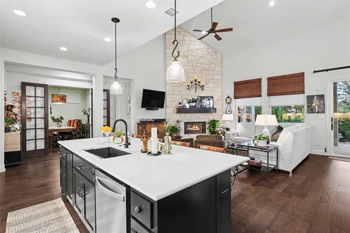 A spacious open-concept floor plan connects the kitchen island directly to the fireplace-centered living area.