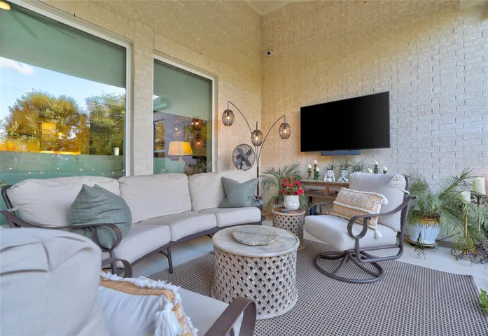 An inviting covered patio features durable brick walls and tall windows looking indoors.