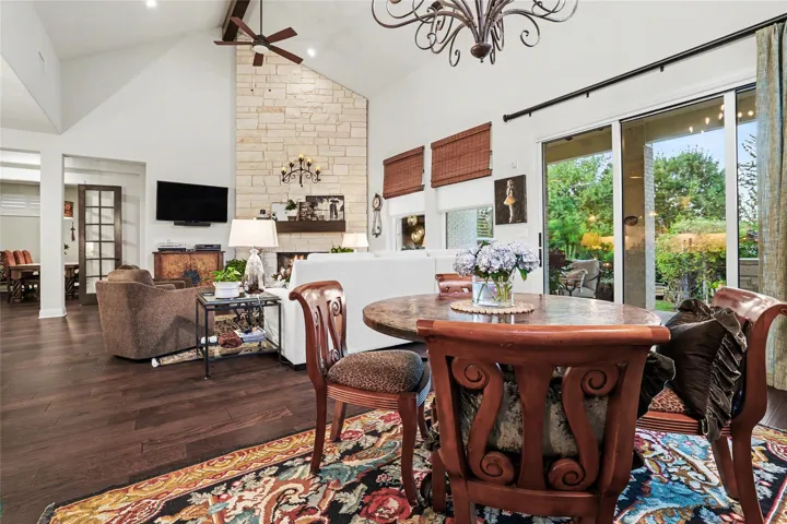 A soaring stone fireplace anchor the living space, seamlessly opening to the outdoors.
