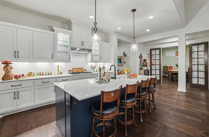Gleaming hardwood floors and a spacious central island define this modern culinary workspace.