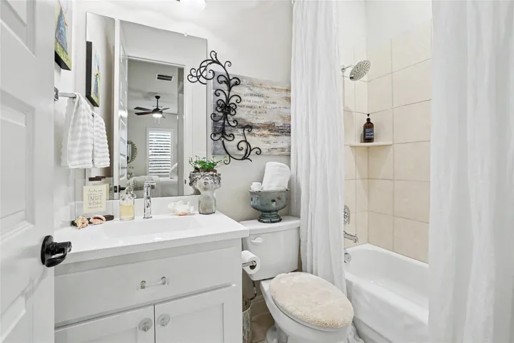 Tiled tub surrounds and a clean white vanity highlight this functional bathroom space.