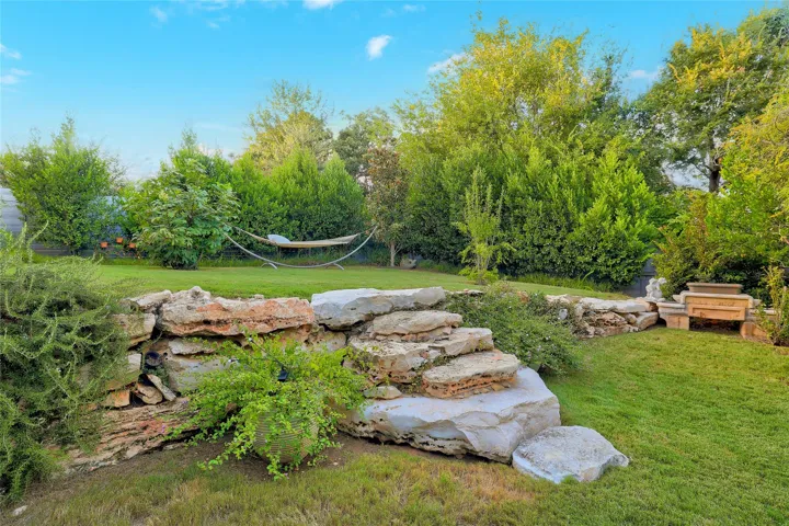 Natural stone steps connect terraced lawn areas in this lushly landscaped backyard retreat.